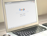 The Google homepage shown on a laptop. Keyword research can make all the difference in terms of search engine optimization.
