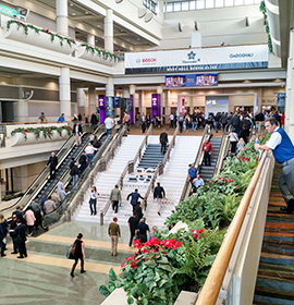 A staircase at a large industry trade show with several attendees. Trade shows are a great way to generate B2B ROI.